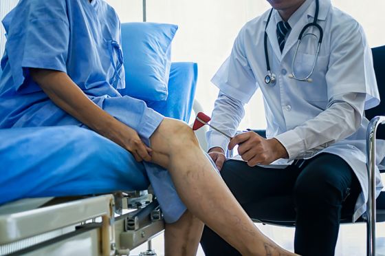 Close-up of female physiotherapist massaging the leg of patient in a physio room.